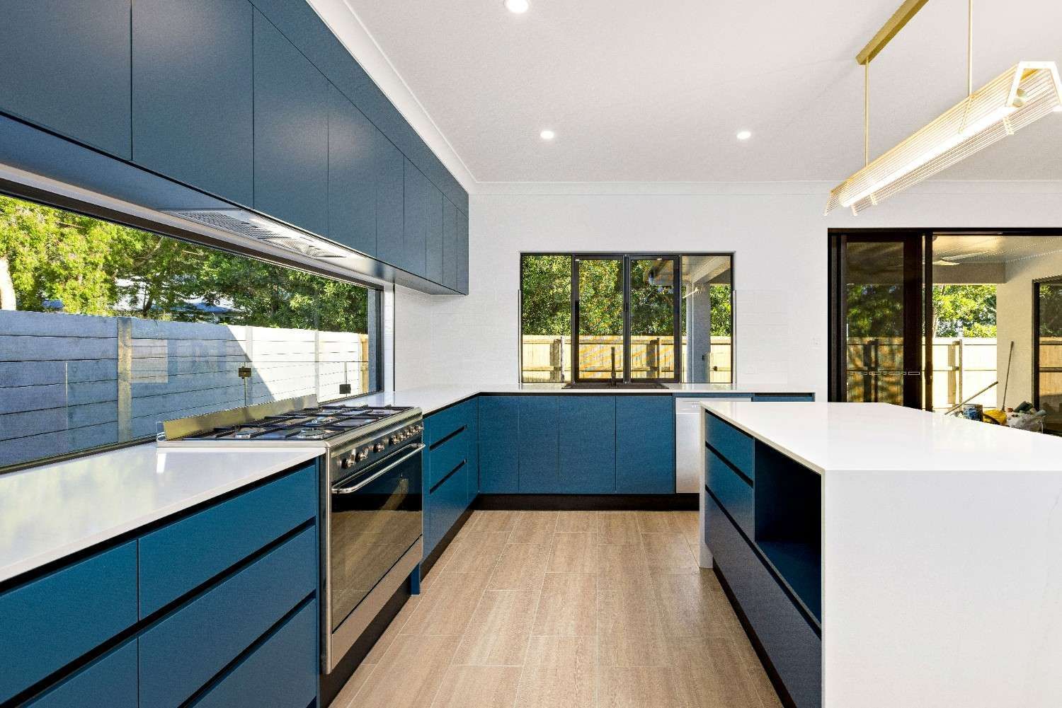 An Empty Living Room With Tile Floors and a Ceiling Fan — Ashlee Jones Homes in Gordonvale, QLD