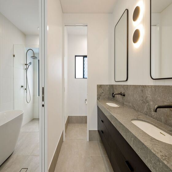 A Bathroom With a Sink and a Large Mirror — Ashlee Jones Homes in Gordonvale, QLD