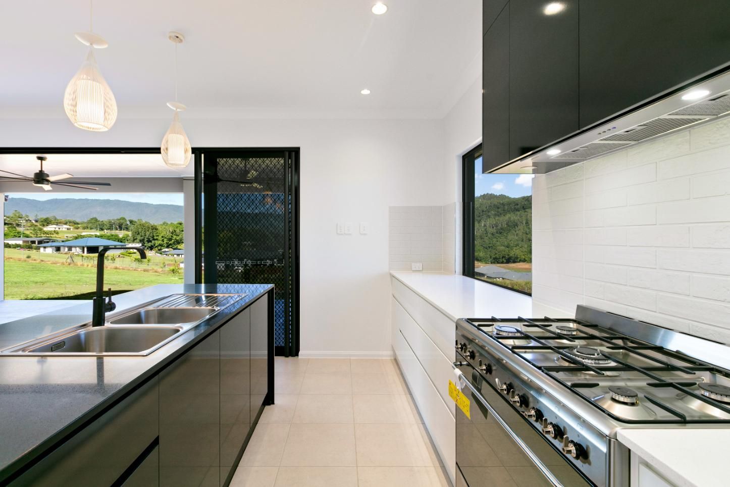 A Kitchen With a Stove, Sink, and a Large Window — Ashlee Jones Homes in Gordonvale, QLD