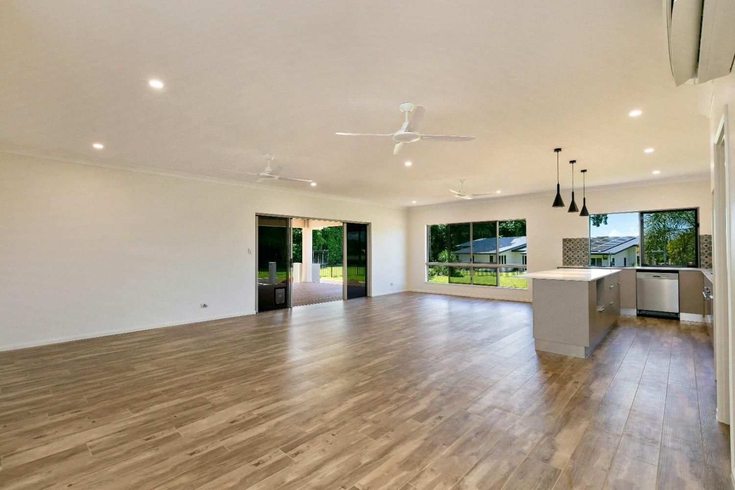 A Empty Room With Hardwood Floors — Ashlee Jones Homes in Gordonvale, QLD