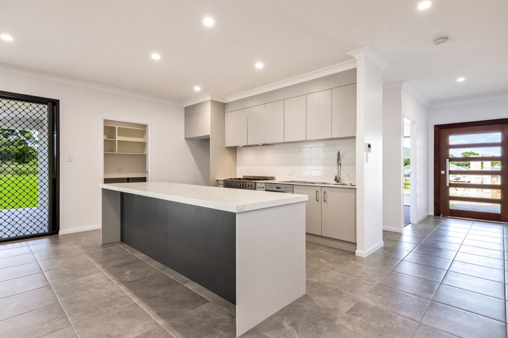 A Kitchen With a Large Island in the Middle of It — Ashlee Jones Homes in Gordonvale, QLD