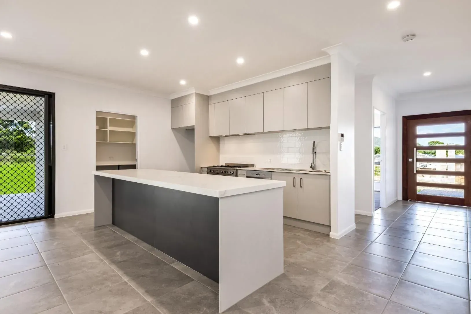 An Empty Room With a Tiled Floor and a Ceiling Fan — Ashlee Jones Homes in Gordonvale, QLD