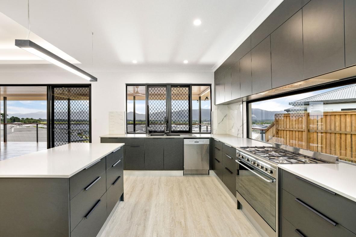 A Kitchen With Stainless Steel Appliances and Gray Cabinets — Ashlee Jones Homes in Gordonvale, QLD