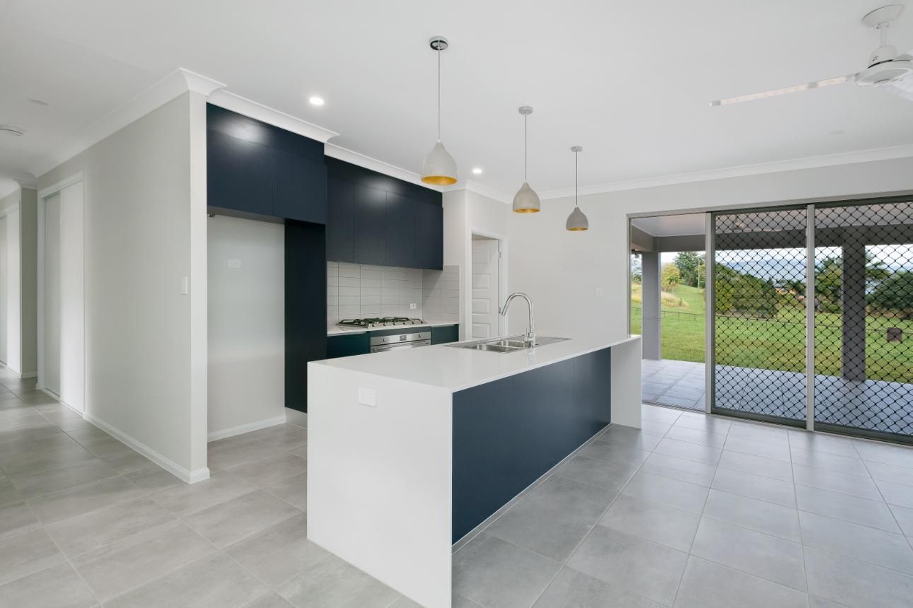 A Kitchen With a Large Island in the Middle of the Room — Ashlee Jones Homes in Gordonvale, QLD
