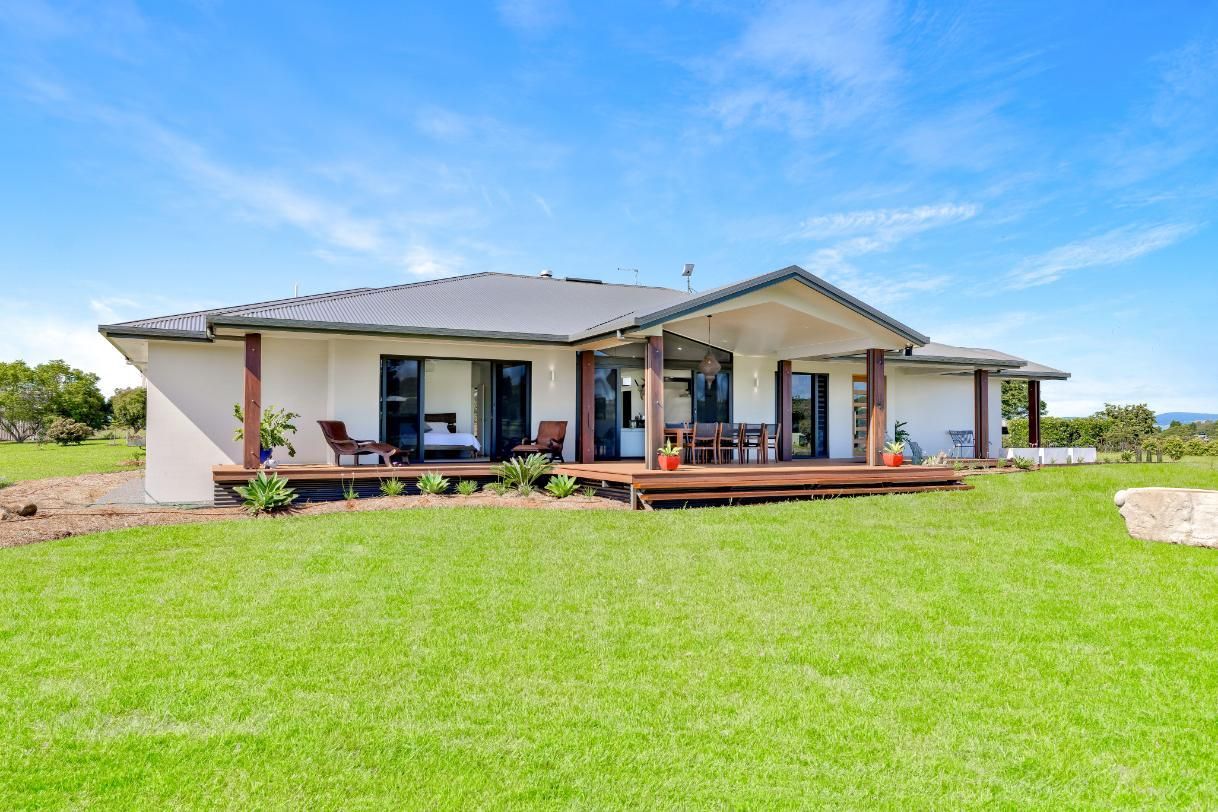 A House is Sitting on Top of a Lush Green Field — Ashlee Jones Homes in Gordonvale, QLD