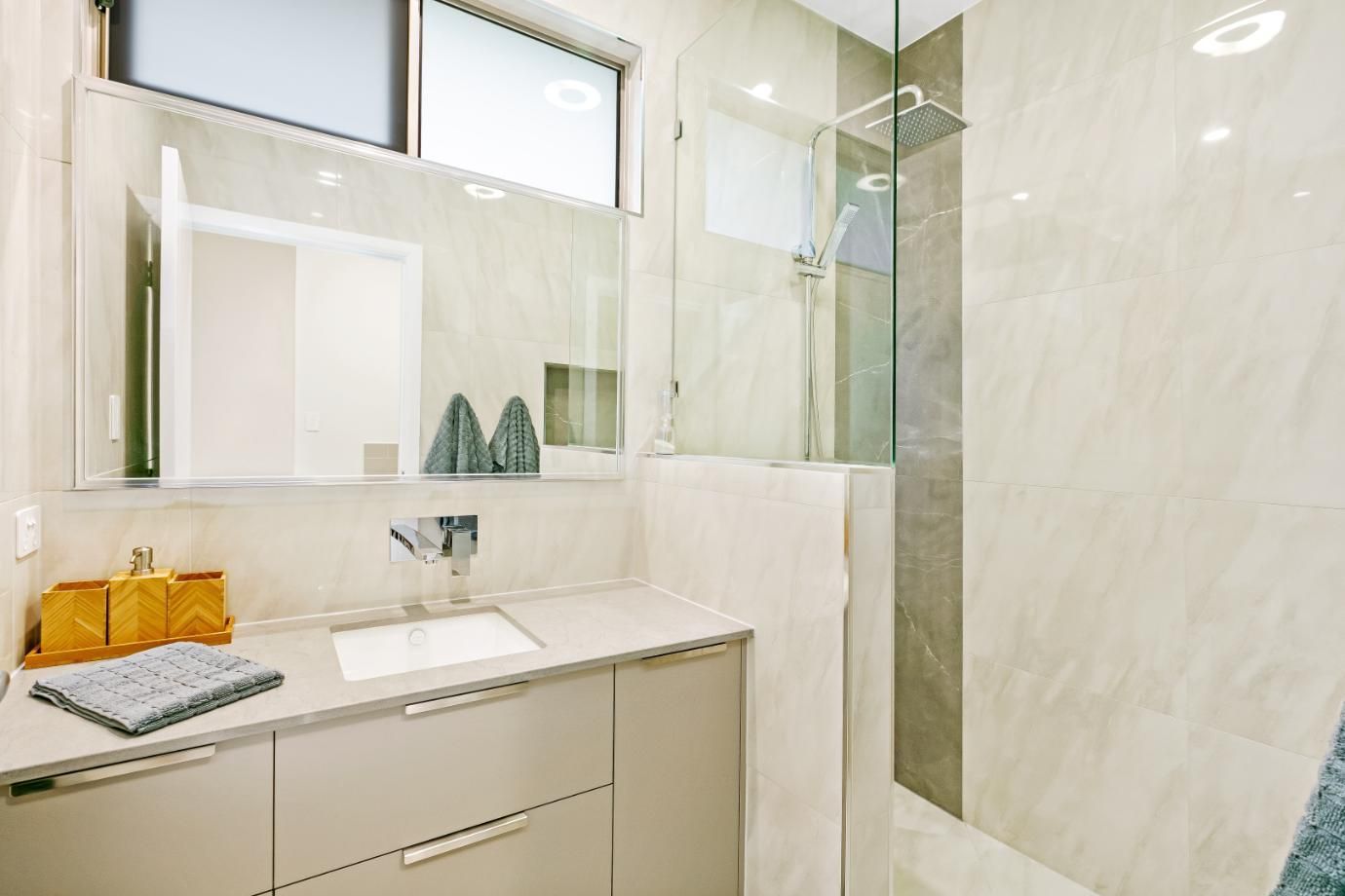 A Bathroom With a Sink, Mirror and Walk in Shower — Ashlee Jones Homes in Gordonvale, QLD