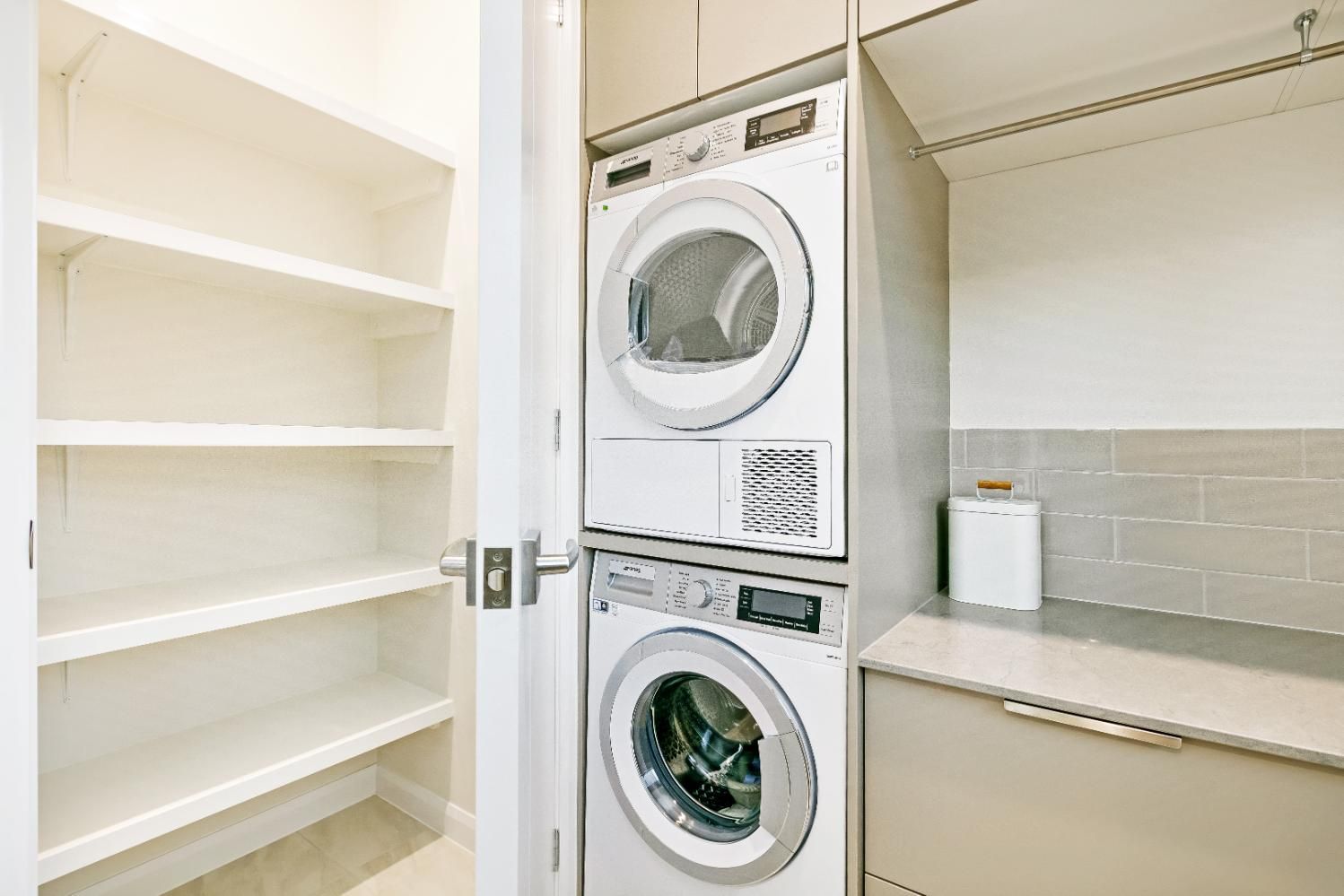 A Washer and Dryer Are Stacked on Top of Each Other in a Laundry Room — Ashlee Jones Homes in Gordonvale, QLD