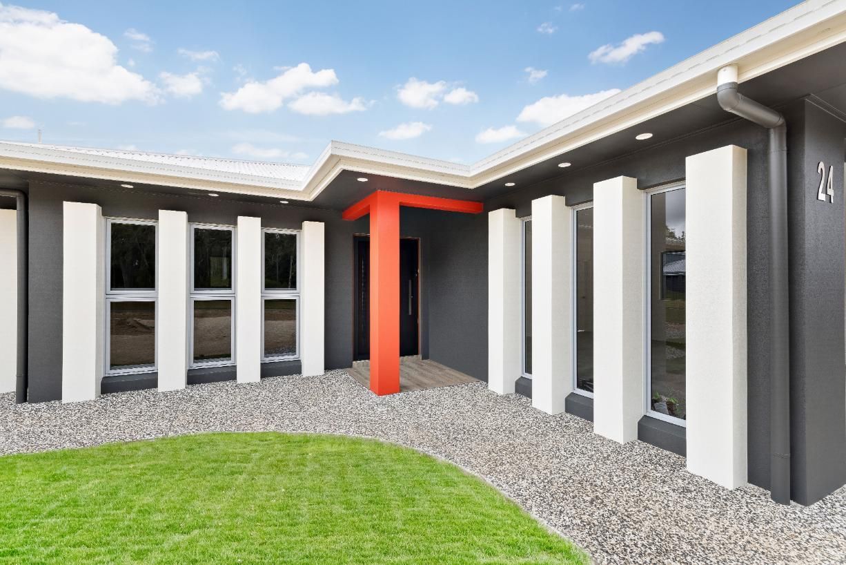 A Black and White House With a Red Pillar in the Middle — Ashlee Jones Homes in Gordonvale, QLD