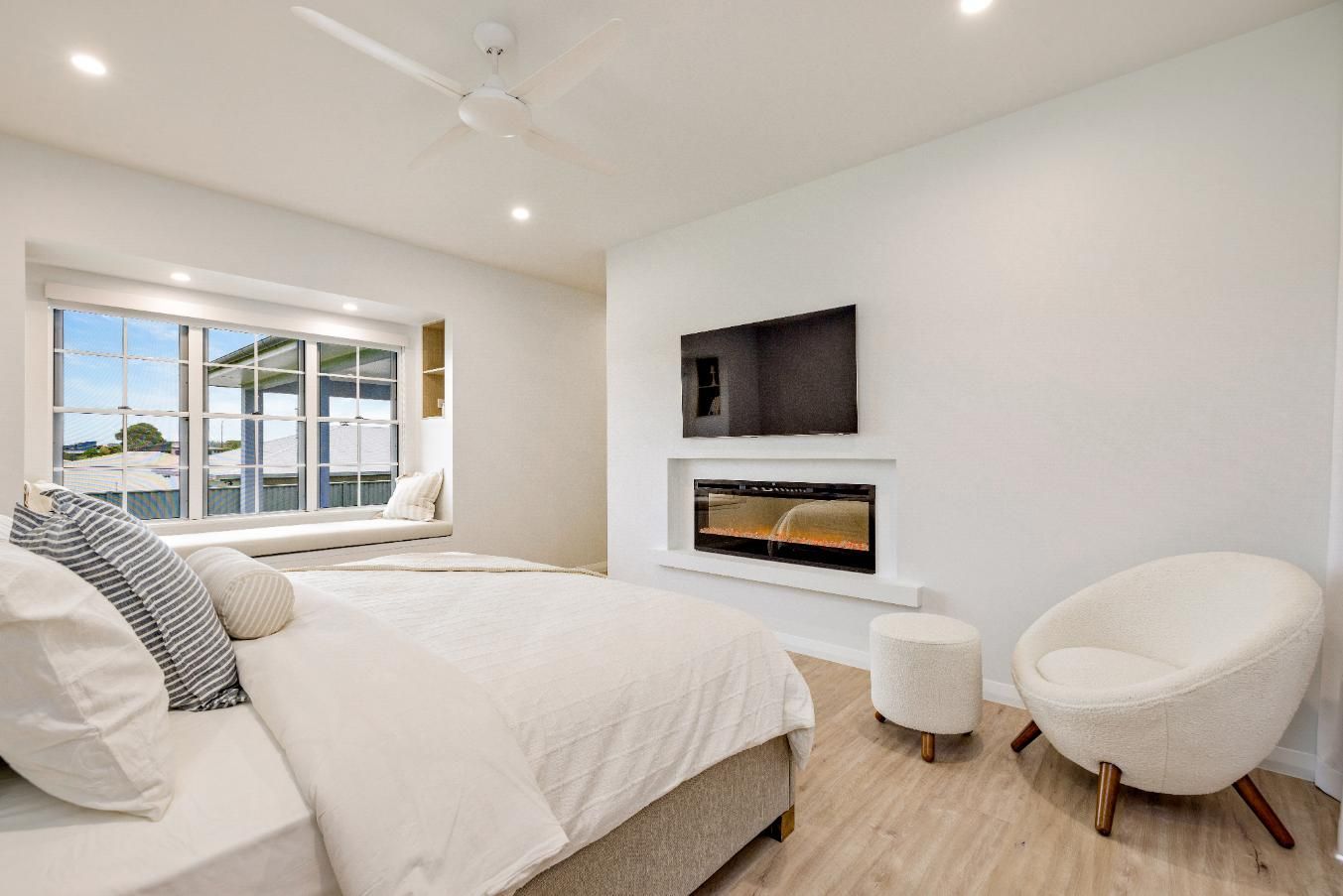 A Bedroom With a Bed, Chair, Television and Fireplace — Ashlee Jones Homes in Gordonvale, QLD