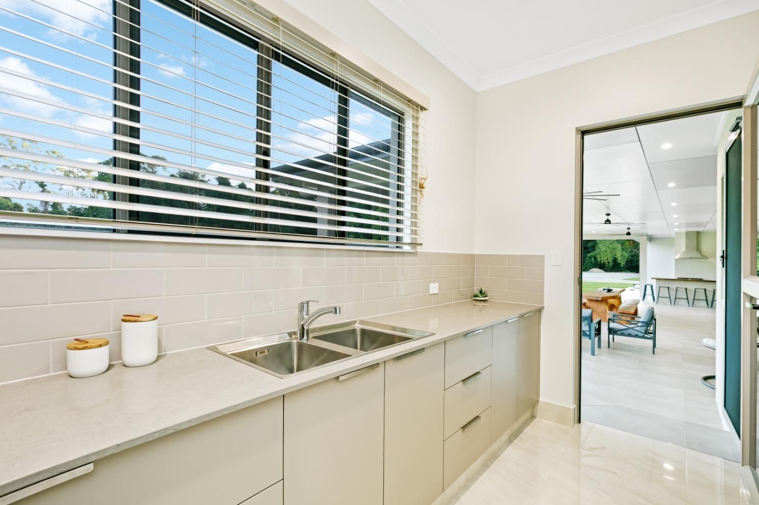 A Kitchen With a Sink and a Window With Blinds — Ashlee Jones Homes in Gordonvale, QLD