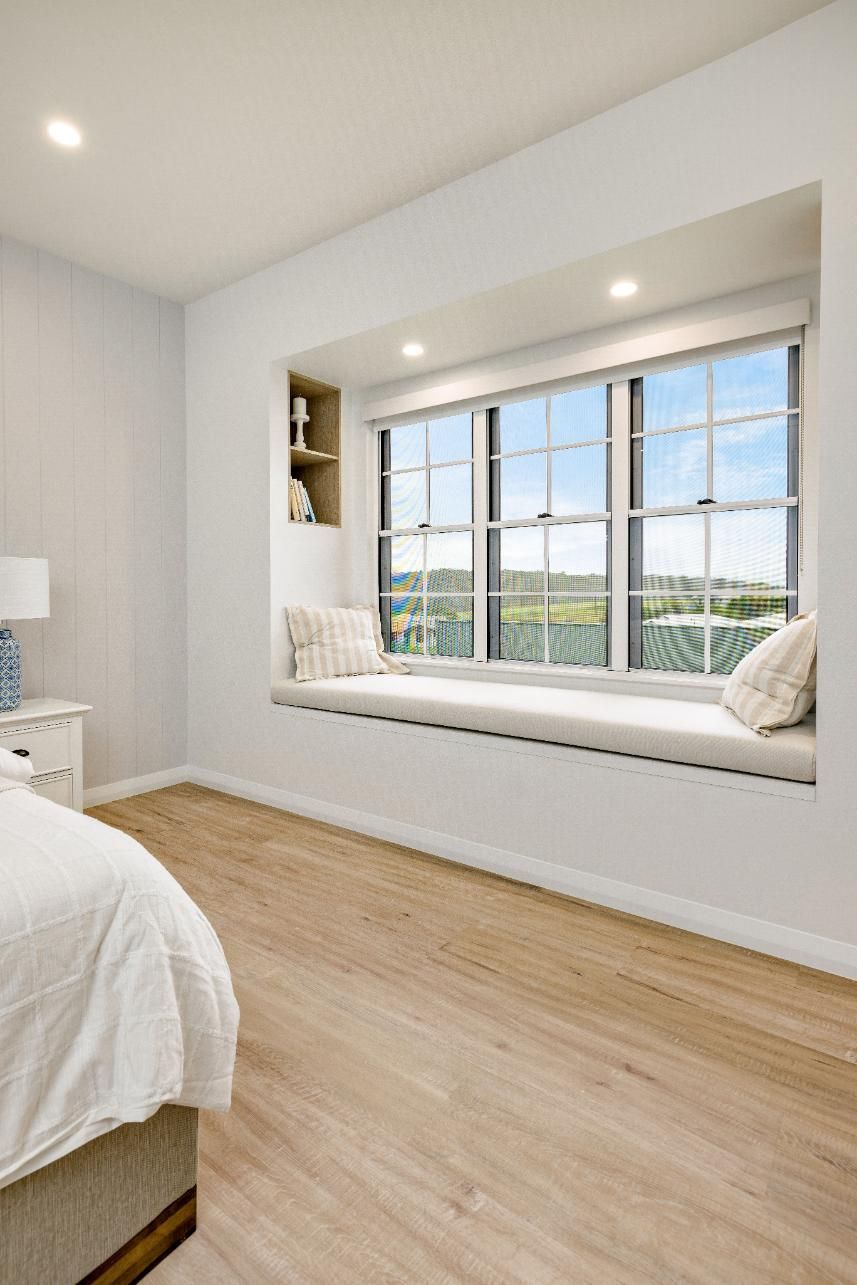 A Bedroom With a Window Seat and a Bed — Ashlee Jones Homes in Gordonvale, QLD
