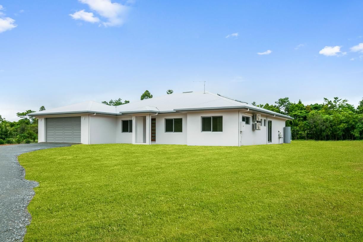 A White House is Sitting on Top of a Lush Green Field — Ashlee Jones Homes in Gordonvale, QLD