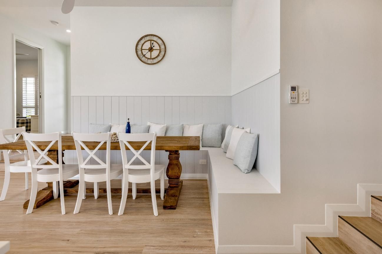 A Dining Room With a Table and Chairs and a Bench — Ashlee Jones Homes in Gordonvale, QLD
