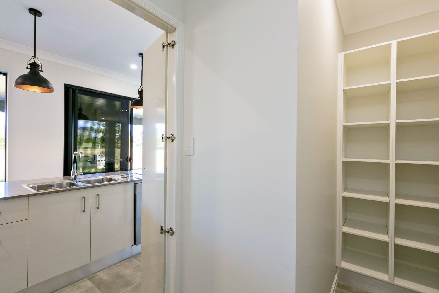 A Kitchen With White Cabinets, a Sink, and Shelves — Ashlee Jones Homes in Gordonvale, QLD