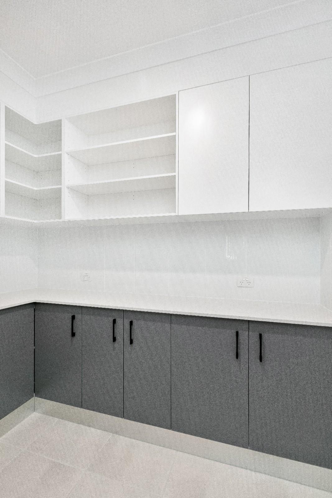 A Kitchen With Gray Cabinets and White Counter Tops — Ashlee Jones Homes in Gordonvale, QLD