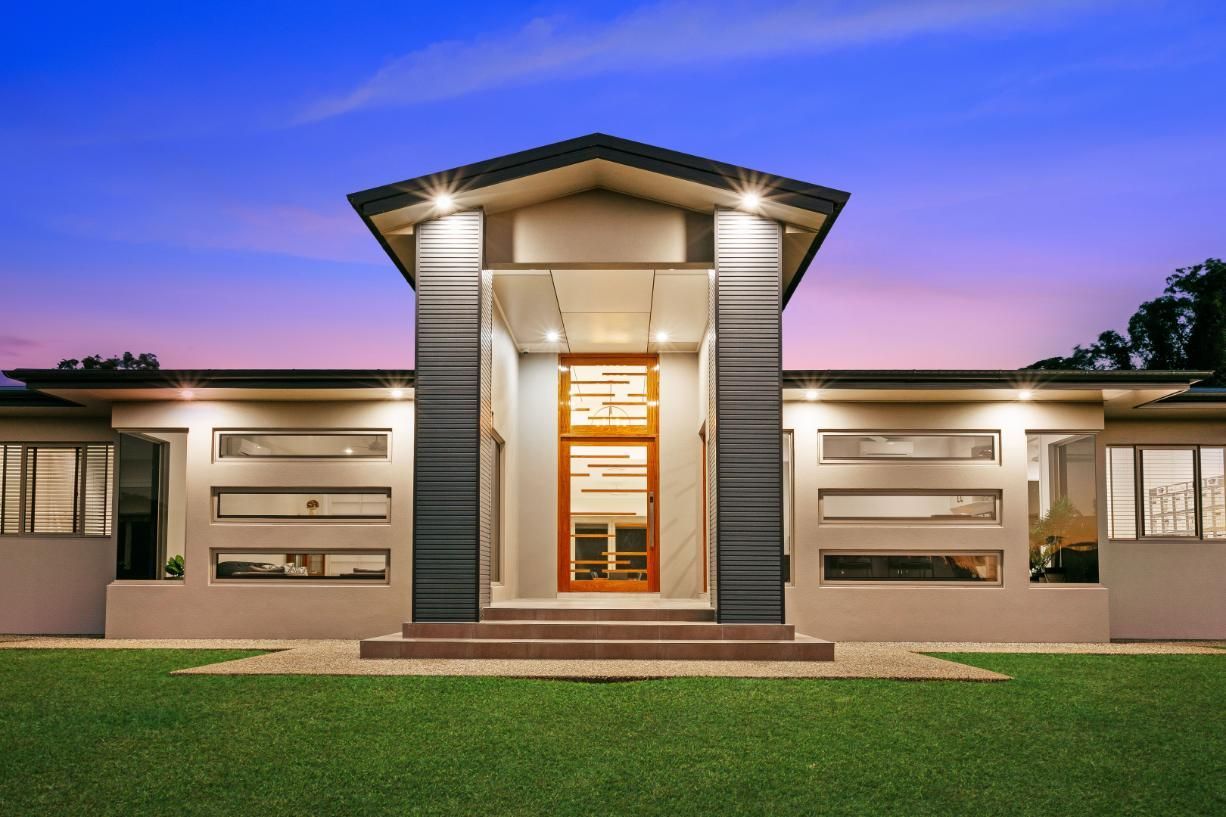 A Large House With a Lush Green Lawn in Front of It — Ashlee Jones Homes in Gordonvale, QLD