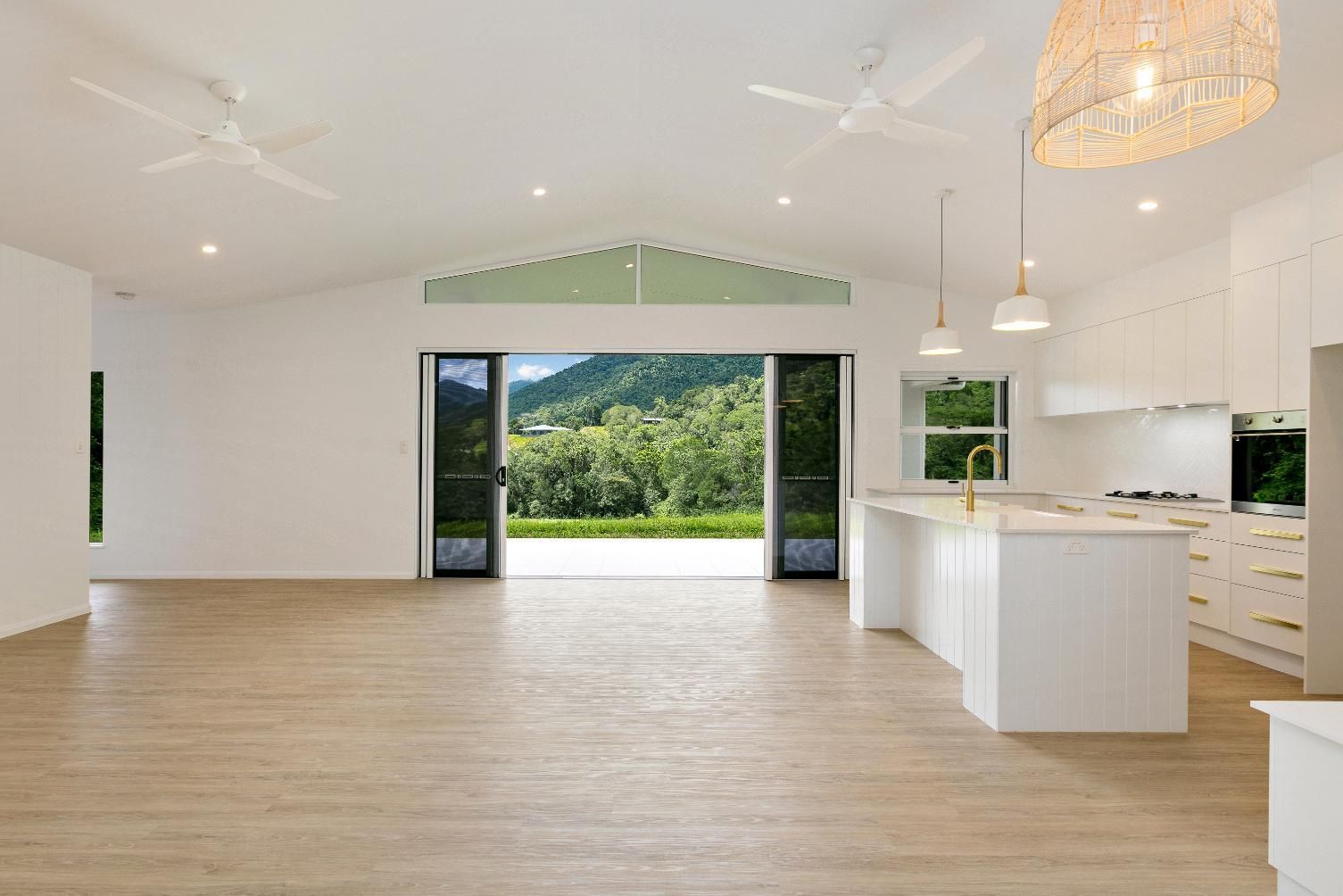 A Large Empty Room With a Kitchen and a View of a Mountain — Ashlee Jones Homes in Gordonvale, QLD