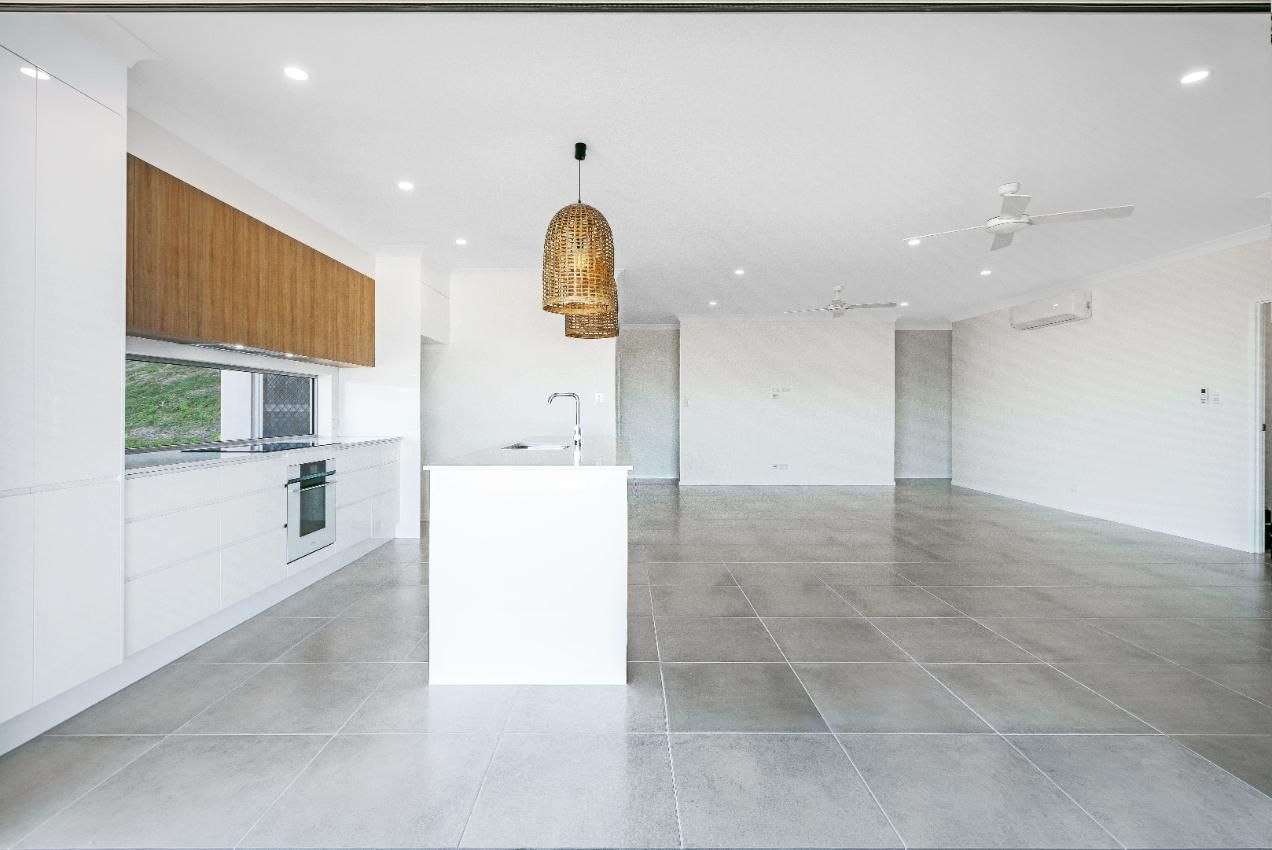 An Empty Kitchen With a Large Island in the Middle of the Room — Ashlee Jones Homes in Gordonvale, QLD
