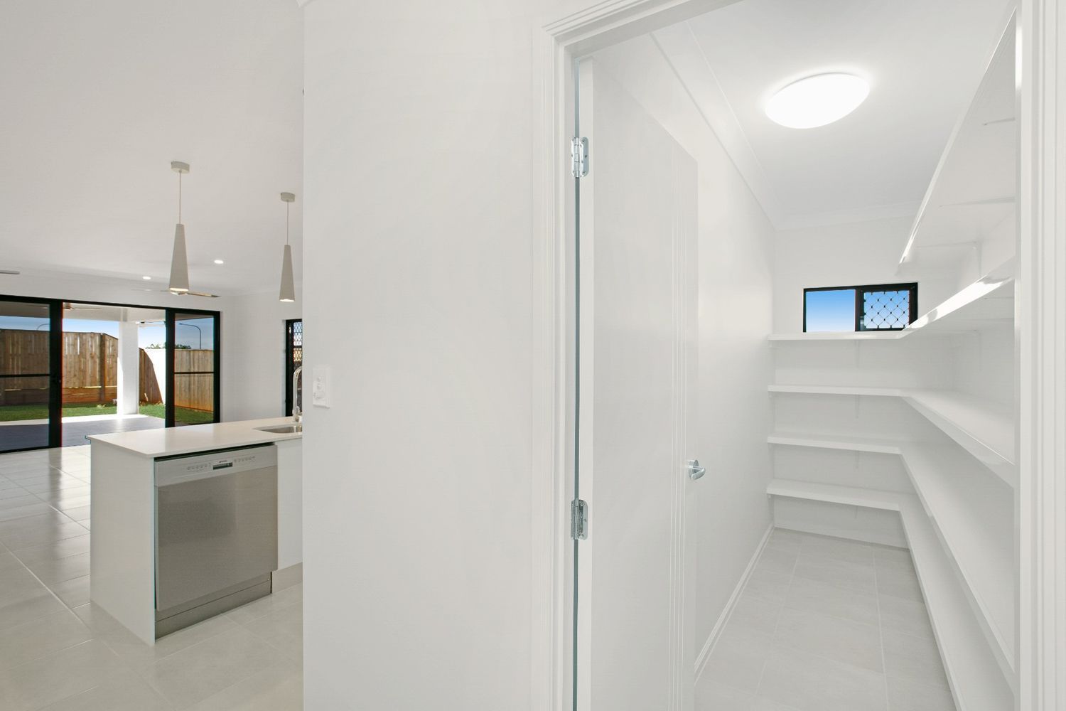 A Kitchen With a Pantry and a Stainless Steel Dishwasher — Ashlee Jones Homes in Gordonvale, QLD