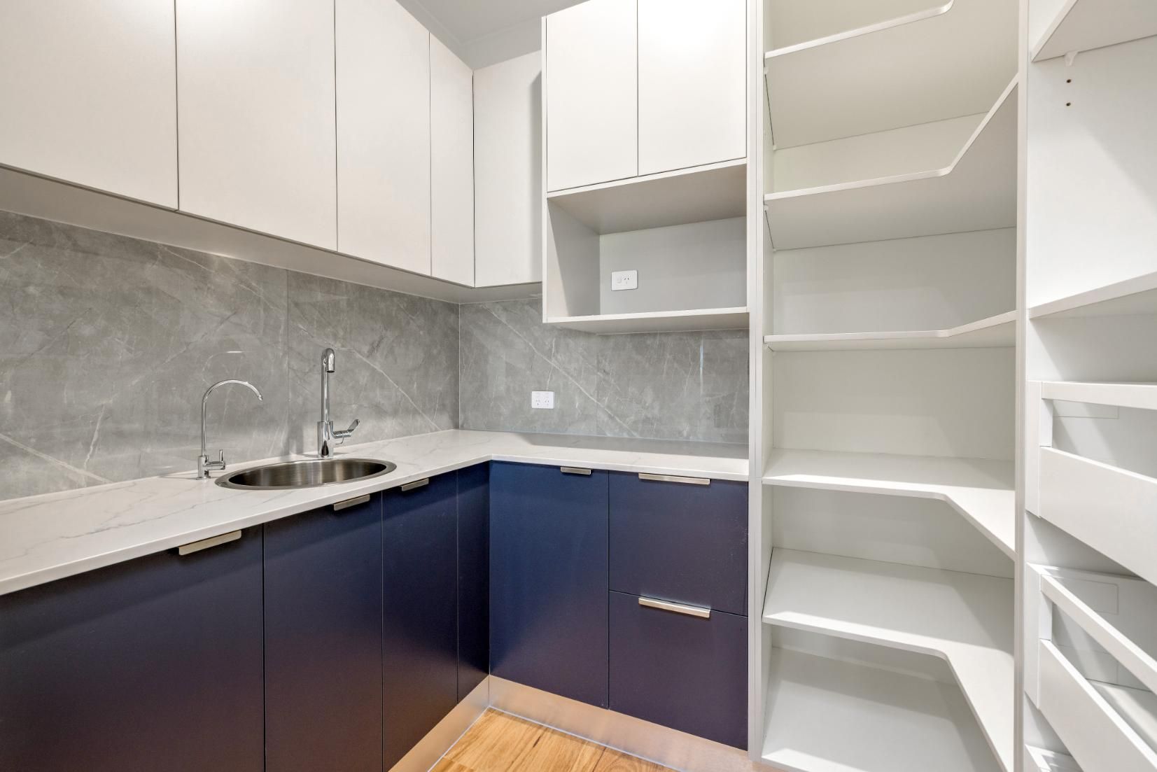 A Kitchen With Blue Cabinets and White Shelves and a Sink — Ashlee Jones Homes in Gordonvale, QLD