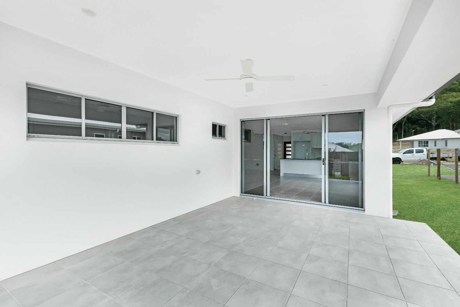 An Empty Patio With Sliding Glass Doors and a Ceiling Fan — Ashlee Jones Homes in Gordonvale, QLD