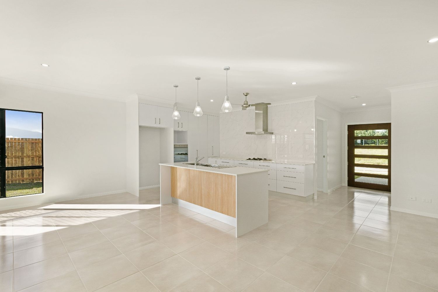 An Empty Kitchen With a Large Island in the Middle of the Room — Ashlee Jones Homes in Gordonvale, QLD