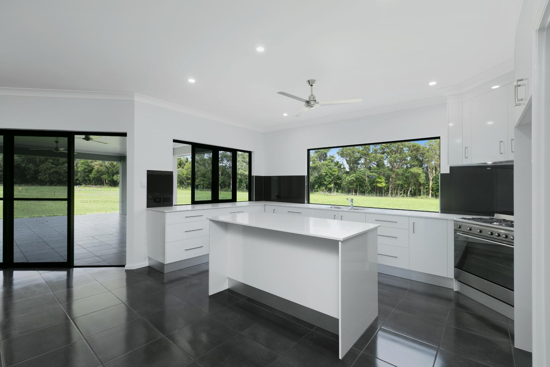An Empty Kitchen With a Large Island in the Middle — Ashlee Jones Homes in Gordonvale, QLD