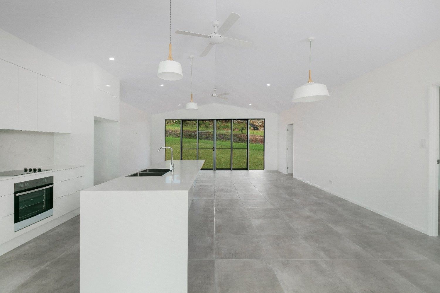 An Empty Kitchen With a Large Island in the Middle of the Room — Ashlee Jones Homes in Gordonvale, QLD