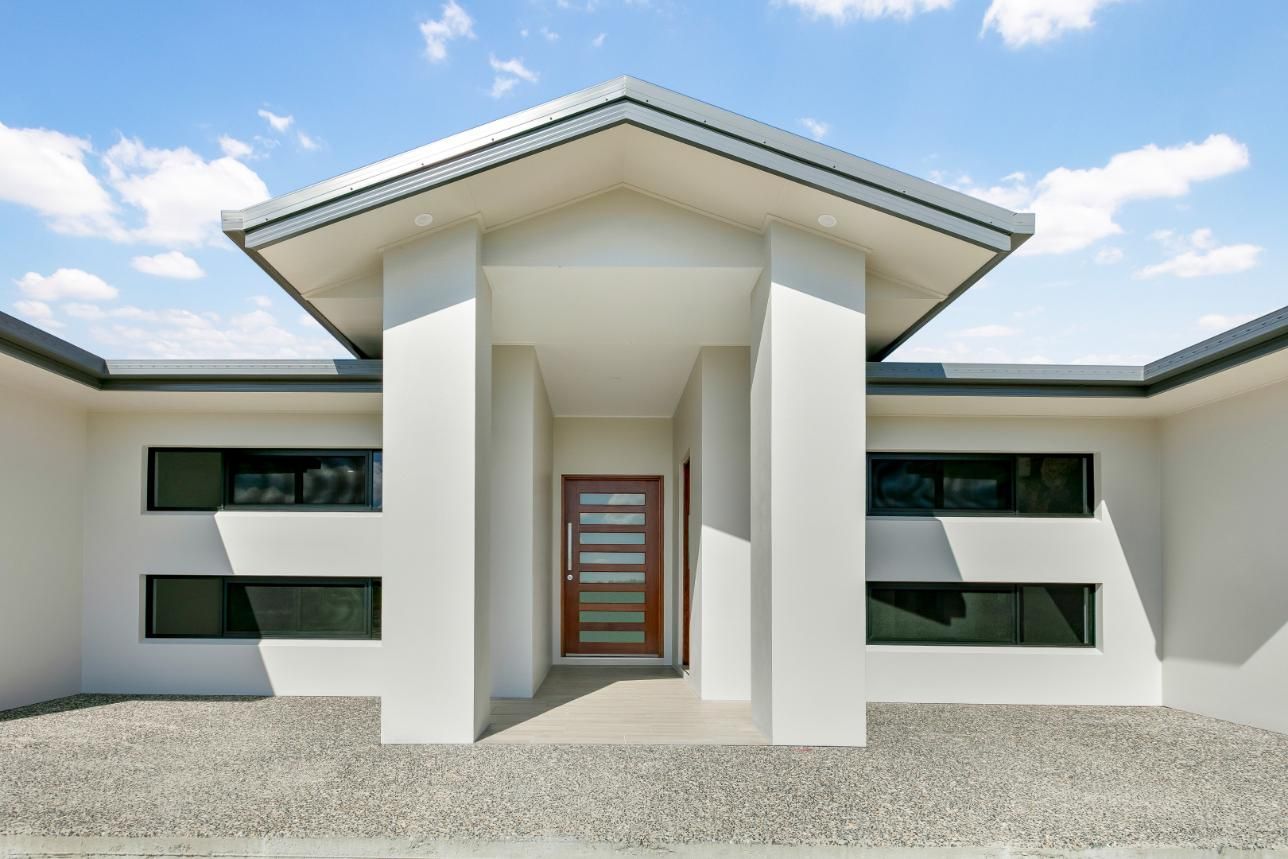 The Front of a White House With a Wooden Door and Windows — Ashlee Jones Homes in Gordonvale, QLD