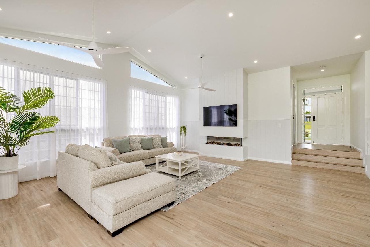 A Living Room With a Couch, Coffee Table, and Television — Ashlee Jones Homes in Gordonvale, QLD
