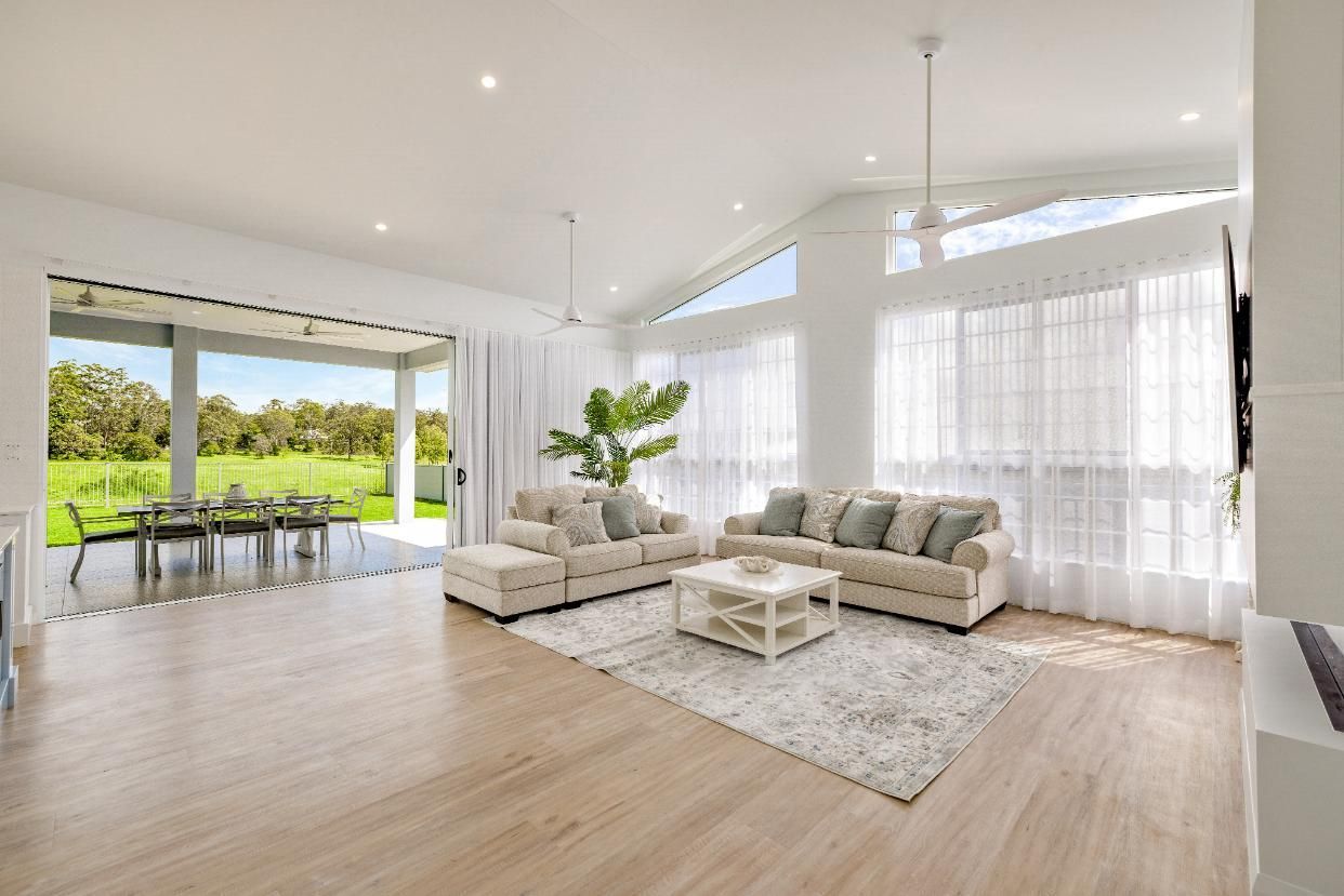 A Living Room With Two Couches, a Table, and a Rug — Ashlee Jones Homes in Gordonvale, QLD