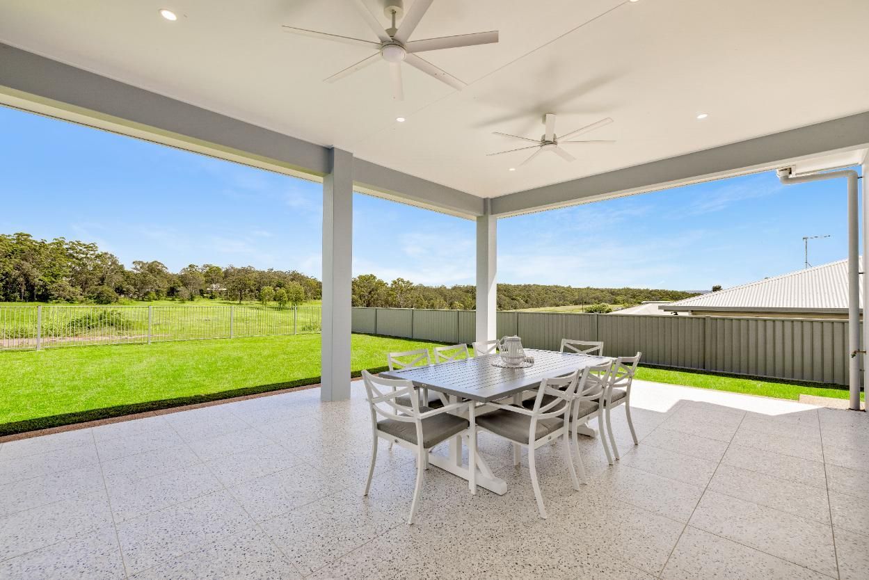 A Patio With a Table and Chairs and a Ceiling Fan — Ashlee Jones Homes in Gordonvale, QLD
