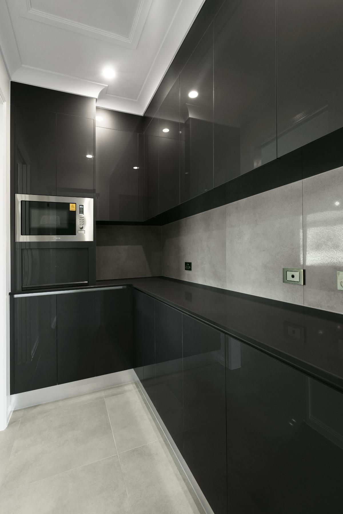 A Kitchen With Black Cabinets and a Microwave Oven — Ashlee Jones Homes in Gordonvale, QLD