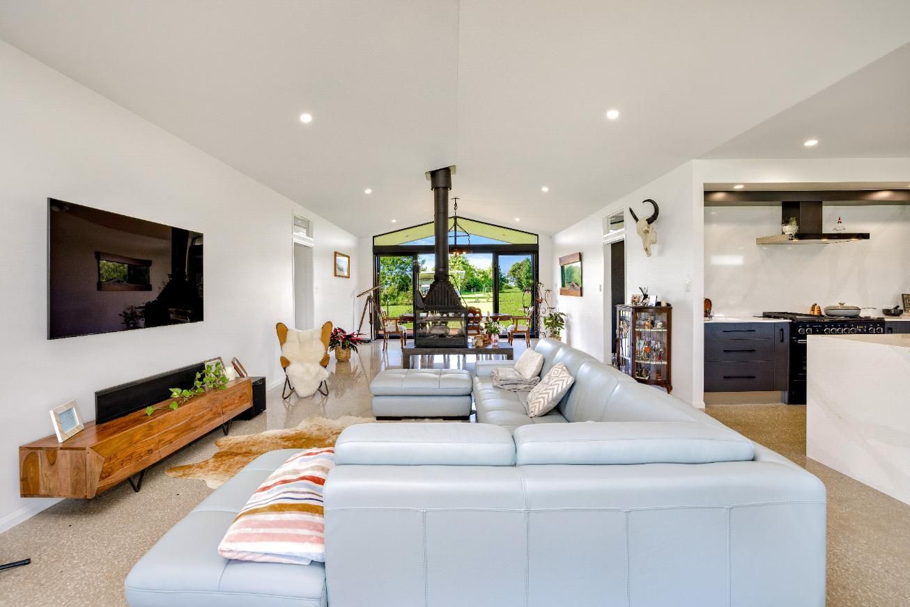 A Living Room With a Couch, Television and Fireplace — Ashlee Jones Homes in Gordonvale, QLD