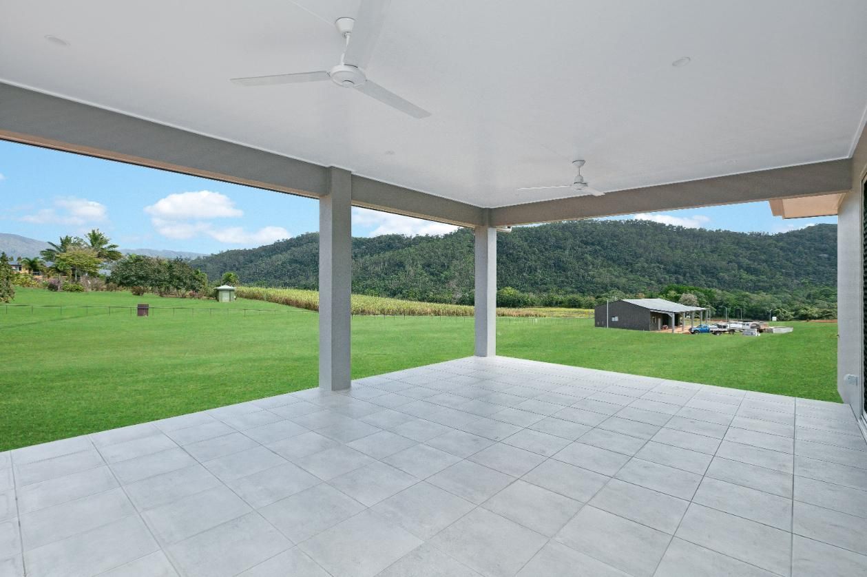 An Empty Patio With a Ceiling Fan and a View of a Grassy Field — Ashlee Jones Homes in Gordonvale, QLD