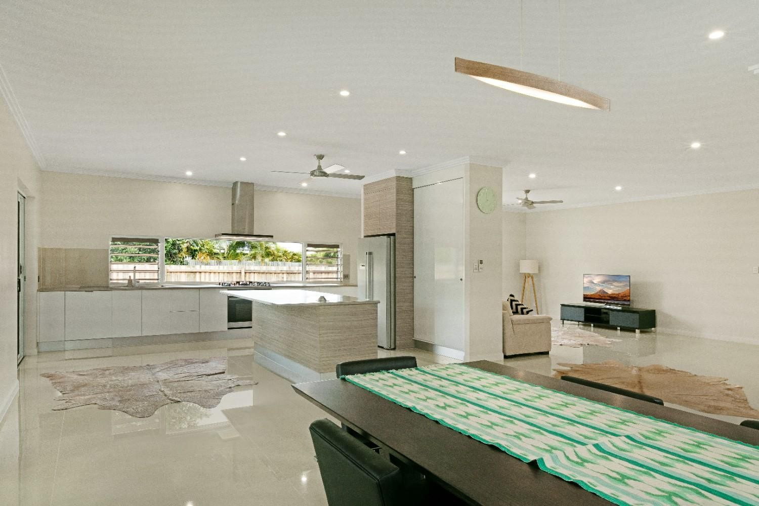 A Kitchen and Dining Room in a House With a Table and Chairs — Ashlee Jones Homes in Gordonvale, QLD