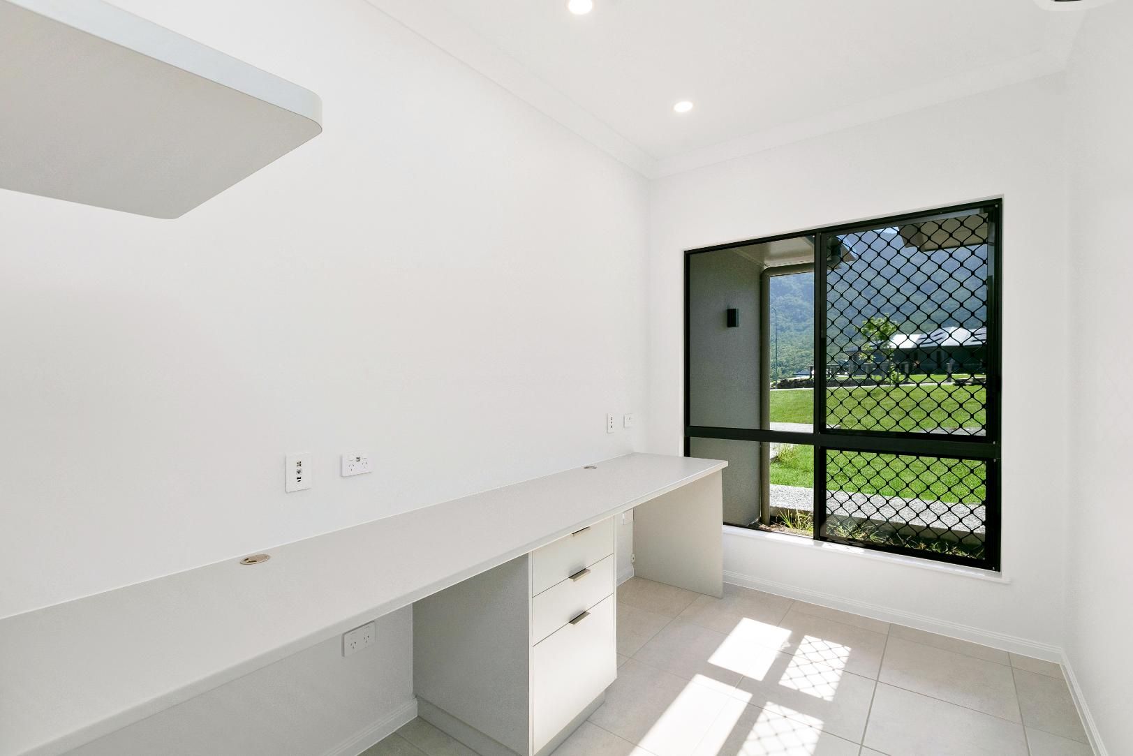 An Empty Room With a Desk and a Window — Ashlee Jones Homes in Gordonvale, QLD
