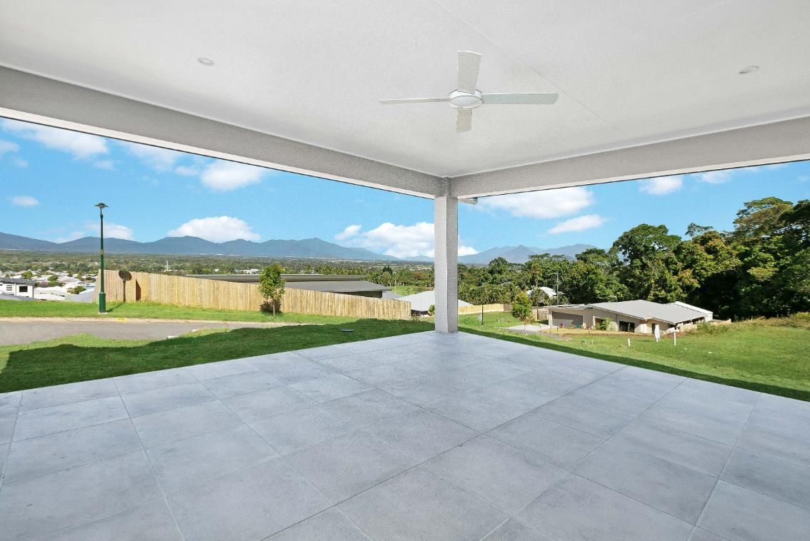 An Empty Patio With a Ceiling Fan and a View of a Lush Green Field — Ashlee Jones Homes in Gordonvale, QLD