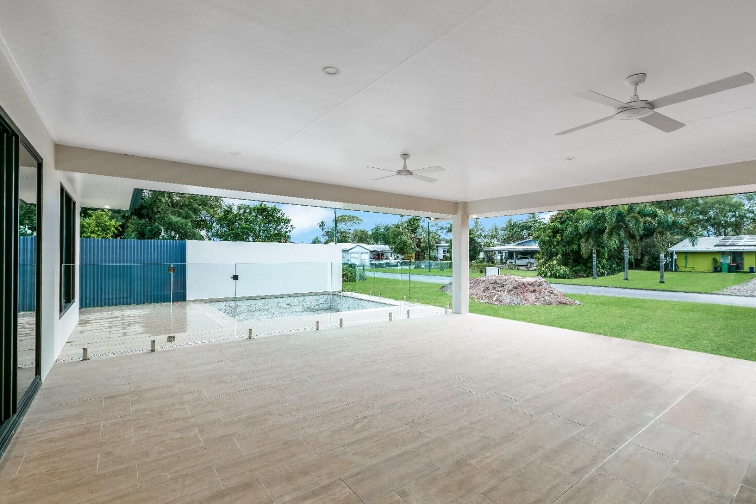 An Empty Patio With a Ceiling Fan and a Pool in the Background — Ashlee Jones Homes in Gordonvale, QLD