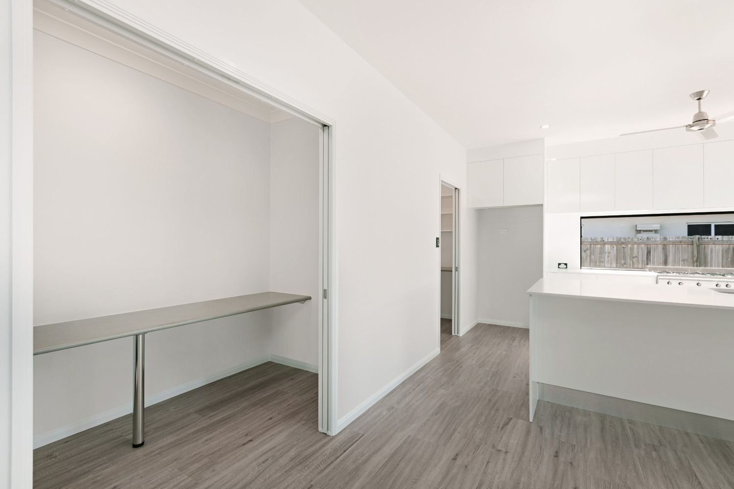 A Kitchen With a Sliding Door Leading to a Closet and a Desk — Ashlee Jones Homes in Gordonvale, QLD