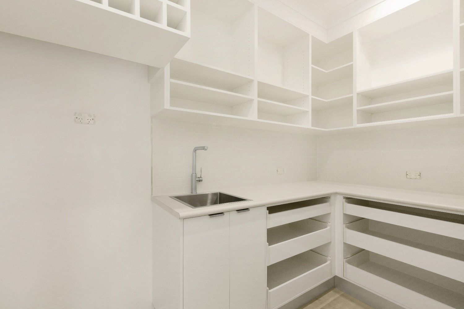 A Kitchen With White Cabinets and Shelves and a Sink — Ashlee Jones Homes in Gordonvale, QLD
