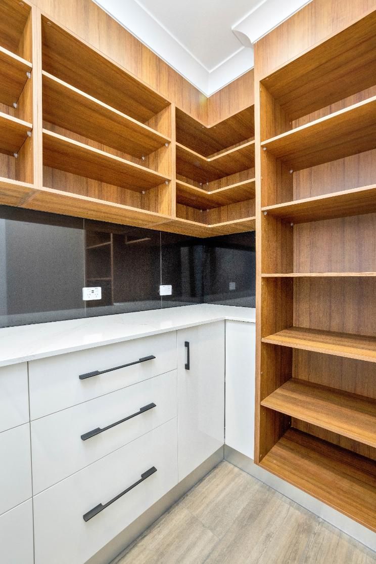 A Kitchen With White Cabinets and Wooden Shelves — Ashlee Jones Homes in Gordonvale, QLD