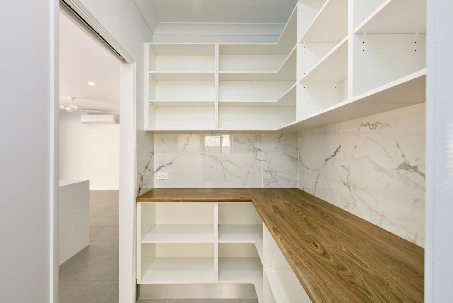 A Pantry With White Shelves and a Wooden Counter Top — Ashlee Jones Homes in Gordonvale, QLD