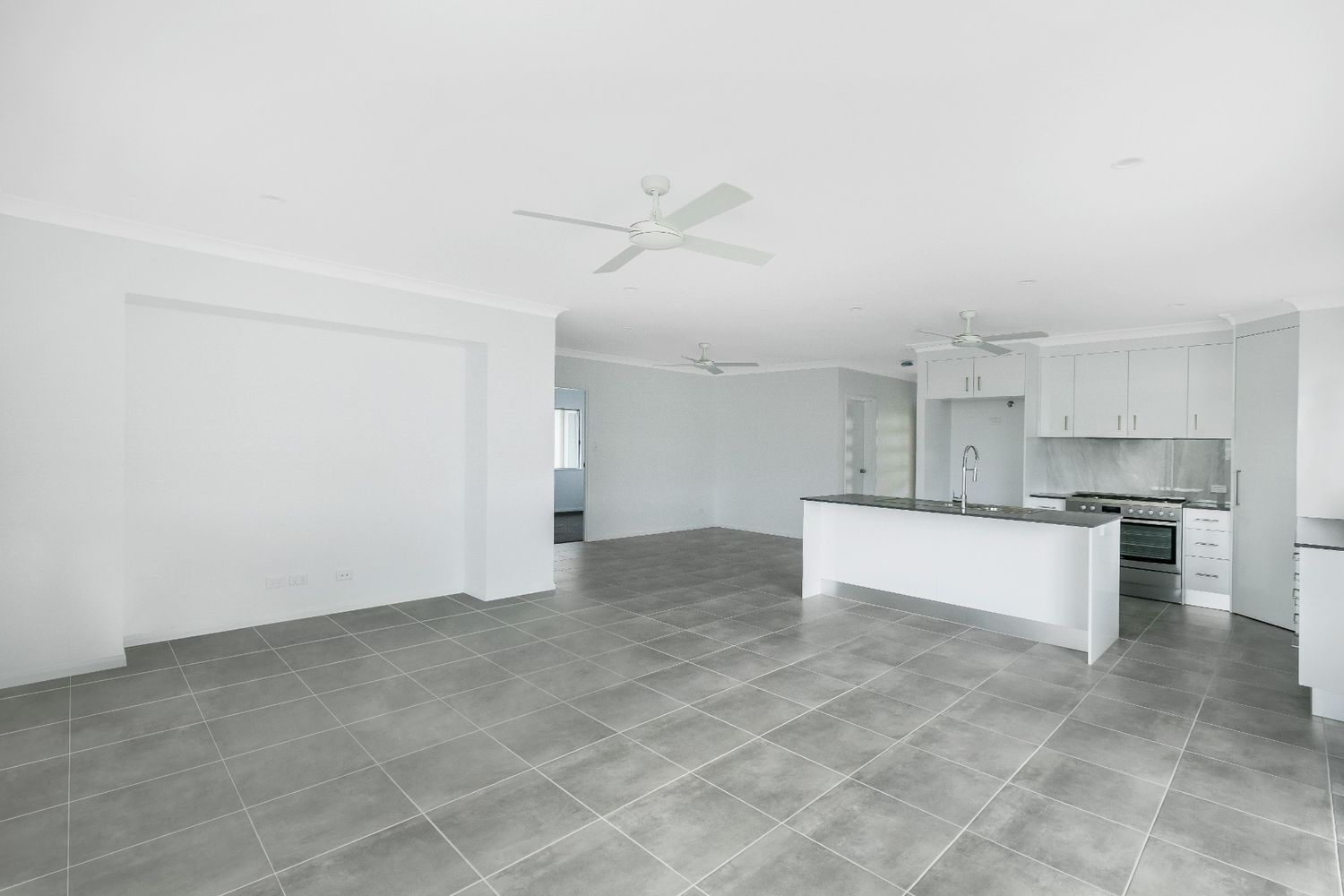 There is a Ceiling Fan in the Living Room and a Kitchen — Ashlee Jones Homes in Gordonvale, QLD
