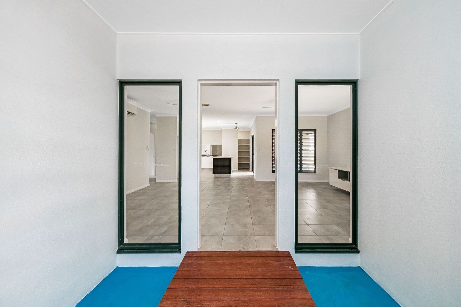 A Room With Two Mirrors on the Wall and a Wooden Floor — Ashlee Jones Homes in Gordonvale, QLD