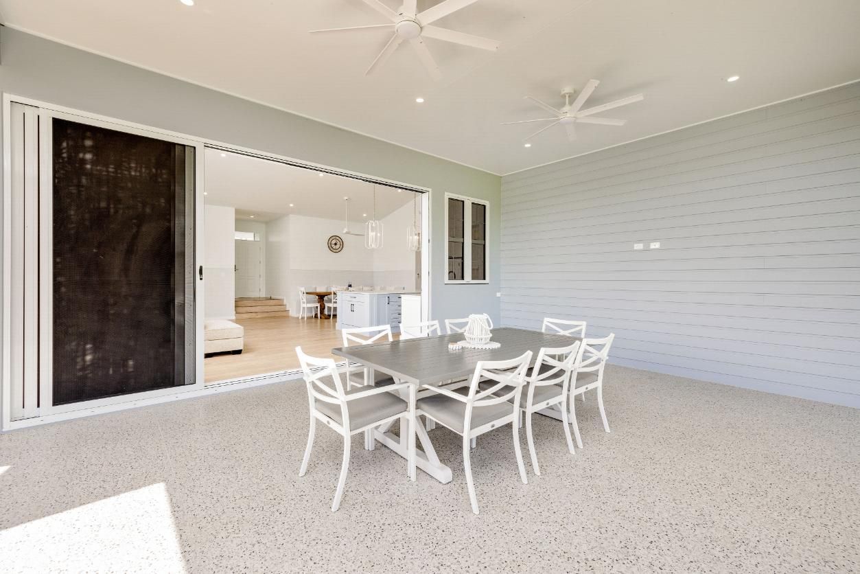 A Patio With a Table and Chairs and a Ceiling Fan — Ashlee Jones Homes in Gordonvale, QLD