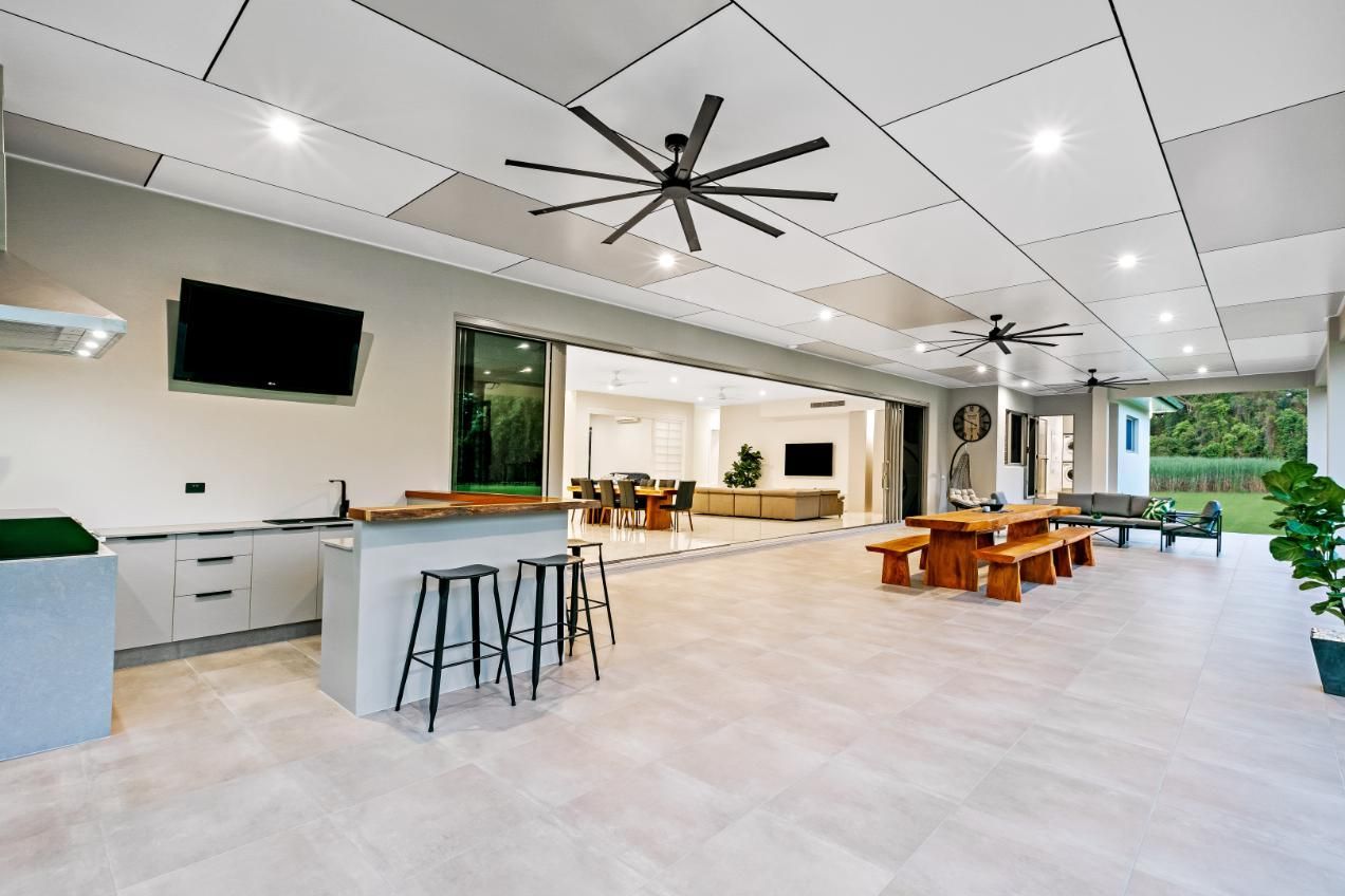 A Large Room With a Ceiling Fan and a Table and Chairs — Ashlee Jones Homes in Gordonvale, QLD
