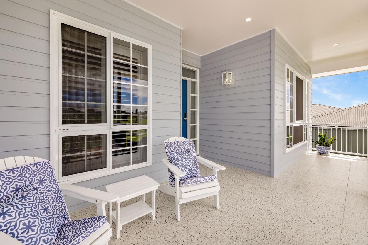 There Are Two Chairs and a Table on the Porch of a House — Ashlee Jones Homes in Gordonvale, QLD