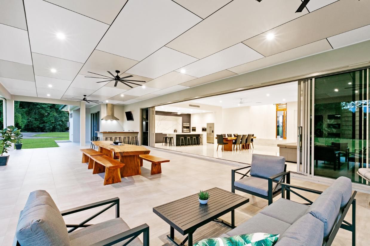 A Living Room With a Table and Chairs and a Ceiling Fan — Ashlee Jones Homes in Gordonvale, QLD