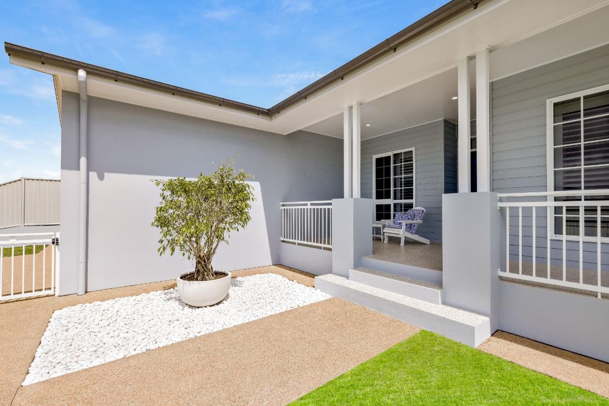 A House With a Porch and a Potted Plant in Front of It — Ashlee Jones Homes in Gordonvale, QLD